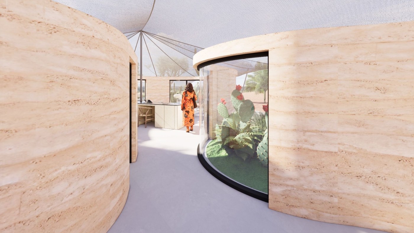 Curved entry hall in warm rammed earth with a glazed courtyard of cacti and ferns