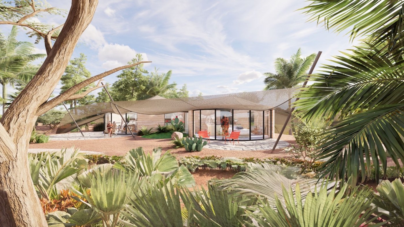 Stone patio with bright orange chairs outside the glass face of the cabin, framed by palms and cacti